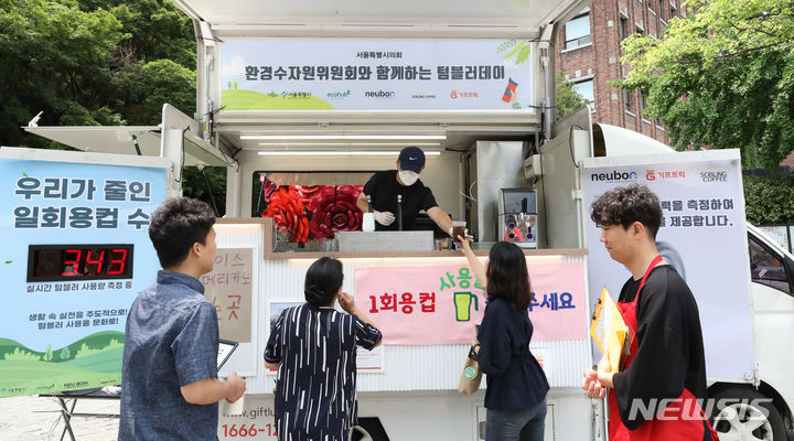 [서울=뉴시스] 김금보 기자 = 28일 오후 서울 중구 정동길 분수대 일대에서 열린 1회용 컵 줄이기를 위한 텀블러데이 행사에서 텀블러를 들고 온 시민들이 무료 음료를 받아 가고 있다. 2023.06.28. kgb@newsis.com