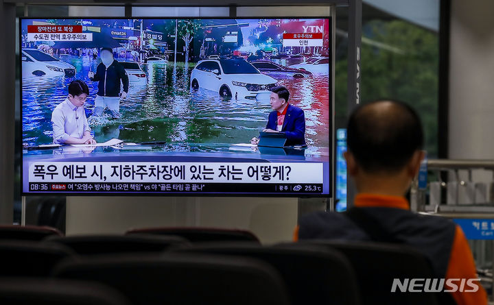 [서울=뉴시스] 정병혁 기자 = 서울과 수도권에 호우주의보가 발효된 29일 오전 서울 강서구 김포국제공항 국제선 입국장에 장마관련 뉴스가 나오고 있다. 2023.06.29. jhope@newsis.com