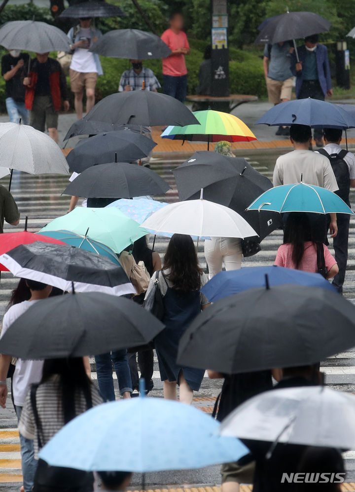 [서울=뉴시스] 조성우 기자 = 서울과 수도권에 호우주의보가 발효된 29일 오전 서울 용산구 용산역 인근에서 시민들이 우산을 쓰고 횡단보도를 건너고 있다. 2023.06.29. xconfind@newsis.com