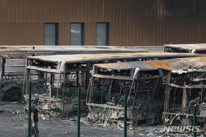 [파리=AP/뉴시스]파리 외곽 오베르비리에의 바스 차고지에서 한 경찰 수사관들이 사흘째 이어진 29일 밤(현지시간) 폭력 시위로 불탄 버스들을 바라보고 있다. 프랑스 전국을 충격에 빠뜨린 경찰의 검문 중 17살 배달 소년 사살에 분노한 시위가 전국에서 29일 밤(현지시간) 사흘째 이어지면서 600명이 넘는 시위대가 체포되고 최소 200명의 경찰관들이 부상했다. 2023.06.30.