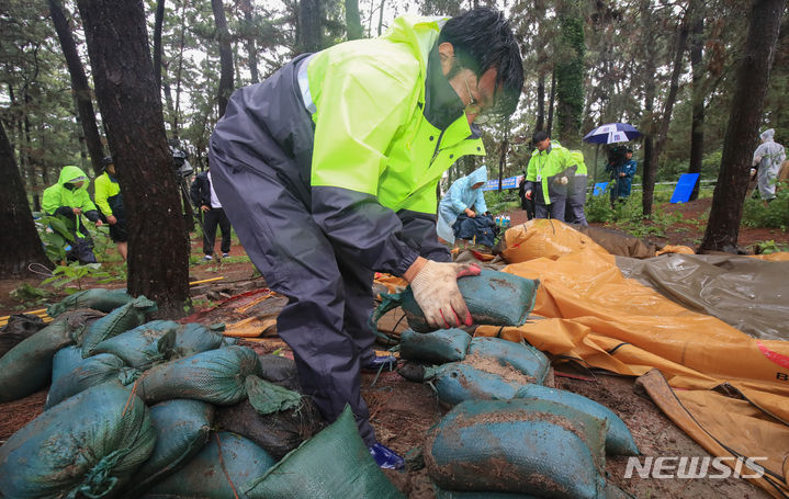 [제주=뉴시스] 우장호 기자 = 장맛비가 내리는 30일 오후 제주시 한림읍 금능해수욕장 인근 야영장에서 제주시청 관계자들이 '알박기' 텐트를 철거하고 있다. 제주시는 시민과 관광객이 효율적으로 해수욕장과 야영장을 사용할 수 있도록 7월1일부터 8월31일까지 협재·금능 청년회에 한시적으로 운영을 위탁해 유료화할 계획이다. 2023.06.30. woo1223@newsis.com