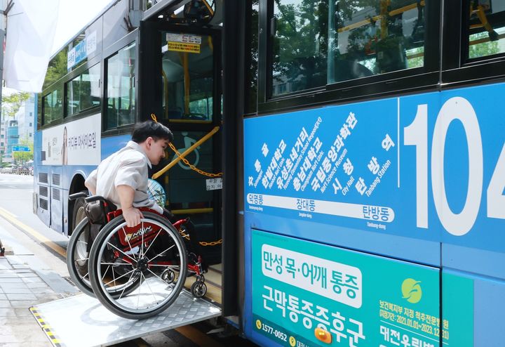 [대전=뉴시스] 조명휘 기자 = 대전시 교통약자 저상버스 예약서비스 개시를 기념해 3일 오후 대전시청 버스정류장에서 교통약자가 버스에 승차하고 있다. (사진= 대전시 제공) 2023.07.03. photo@newsis.com *재판매 및 DB 금지