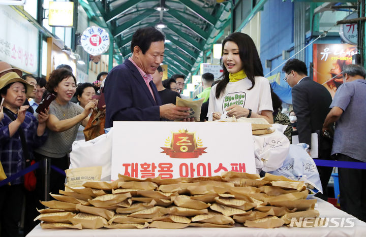 [강릉=뉴시스] 홍효식 기자 = 윤석열 대통령 부인 김건희 여사가 3일 오후 강원도 강릉 중앙·성남시장을 방문해 재사용 아이스팩을 최영철 상인회장에게 전달하고 있다. 김 여사는 시장 방문에 앞서 경포 해변정화활동 나섰다. 그는 새마을회, 대학생 자원봉사자들이 함께 했으며 백사장과 솔밭 일대에 버려진 쓰레기와 폐플라스틱 등을 줍고 주변을 청소했다.2023.07.03. yesphoto@newsis.com