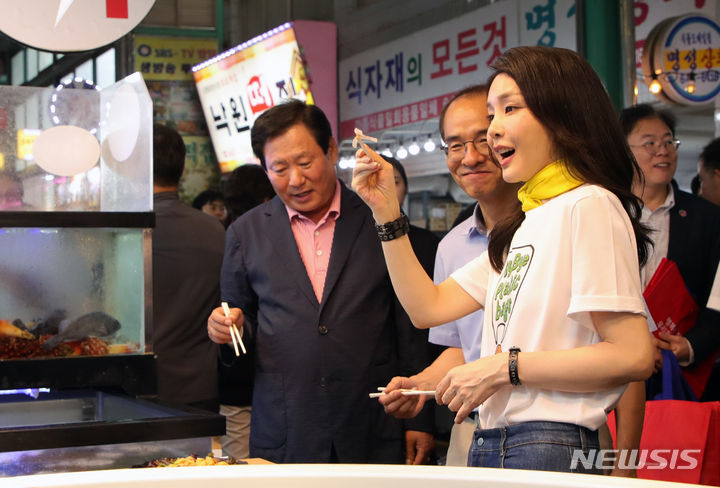 [강릉=뉴시스] 홍효식 기자 = 윤석열 대통령 부인 김건희 여사가 3일 오후 강원도 강릉 중앙·성남시장을 방문해 오징어회를 시식하고 있다. 2023.07.03. yesphoto@newsis.com