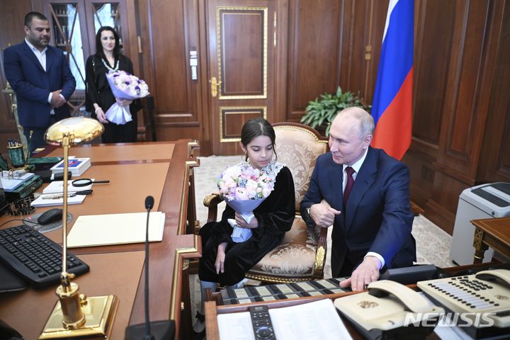 [모스크바=AP/뉴시스] 블라디미르 푸틴 러시아 대통령이 4일(현지시각) 모스크바 크렘린궁에서 다게스탄 공화국 데르벤트에서 온 8세 소녀 라이사트 아키포바와 얘기하고 있다. 푸틴 대통령은 지난달 28일 데르벤트를 방문했을 때 자신을 만나지 못해 눈물 흘리는 라이사트의 사진을 뒤늦게 보고 라이사트 가족을 크렘린궁에 초대했다. 푸틴 대통령은 안톤 실루아노프 재무장관에게 전화해&nbsp; 라이사트를 바꿔주었고 라이사트는 다게스탄에 대한 예산 지원을 요청해 50억 루블(약 713억 원)의 예산 지원을 약속받았다. 2023.07.05.