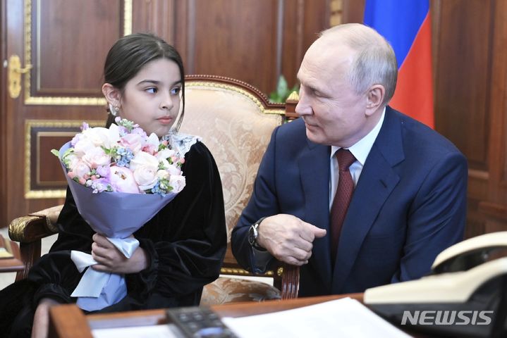 [모스크바=AP/뉴시스] 블라디미르 푸틴 러시아 대통령이 4일(현지시각) 모스크바 크렘린궁에서 다게스탄 공화국 데르벤트에서 온 8세 소녀 라이사트 아키포바와 얘기하고 있다. 푸틴 대통령은 지난달 28일 데르벤트를 방문했을 때 자신을 만나지 못해 눈물 흘리는 라이사트의 사진을 뒤늦게 보고 라이사트 가족을 크렘린궁에 초대했다. 푸틴 대통령은 안톤 실루아노프 재무장관에게 전화해&nbsp; 라이사트를 바꿔주었고 라이사트는 다게스탄에 대한 예산 지원을 요청해 50억 루블(약 713억 원)의 예산 지원을 약속받았다. 2023.07.05.