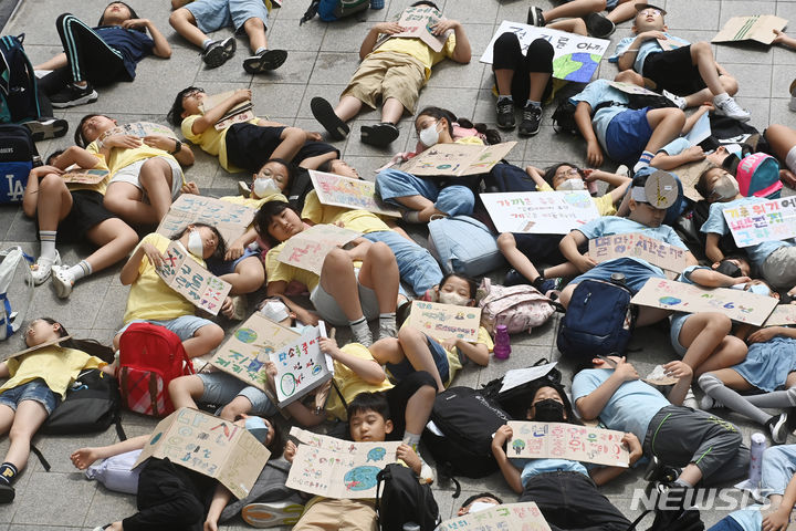 [수원=뉴시스] 김종택 기자 = 5일 경기도 수원시 팔달구 수원시청에서 신영초등학교 학생들이 수원환경운동연합, 다산인권센터와 함께 기후 위기 대응을 촉구하는 '다이-인(Die-in) 퍼포먼스'를 하고 있다. 2023.07.05. jtk@newsis.com