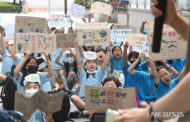 [수원=뉴시스] 김종택 기자 = 5일 경기도 수원시 팔달구 수원시청에서 신영초등학교 학생들이 수원환경운동연합, 다산인권센터와 함께 기후 위기 대응을 촉구하는 퍼포먼스'를 하고 있다. 2023.07.05. jtk@newsis.com