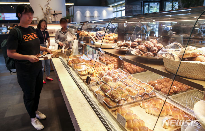 [서울=뉴시스] 정병혁 기자 = 서울시내 빵집을 찾은 시민들이 빵을 고르고 있다. 2023.07.07. jhope@newsis.com