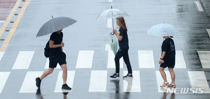 [전주=뉴시스] 김얼 기자 = 연일 장마가 이어지고 있는 7일 전북 전주시 덕진구 견훤로에서 시민들이 우산으로 비를 피하며 횡단보도를 건너고 있다. 2023.07.07. pmkeul@nwsis.com