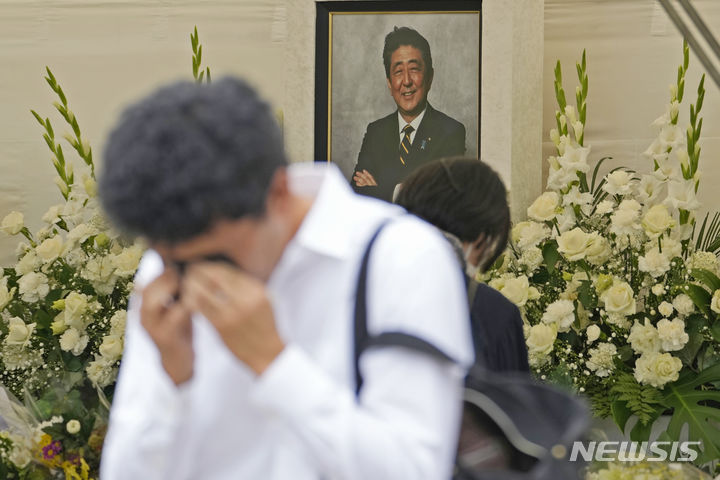 [도쿄=AP/뉴시스] 한 남성이 8일 일본 수도 도쿄 미나토구에 자리한 조죠지 사찰에서 열린 아베 신조 전 일본 총리 1주기 법요에 참석해 흐느끼고 있다. 지난해 7월8일 아베 전 총리는 나라현 나라시에서 참의원 선거 지원 연설 도중 총격을 받아 숨졌다. 2023.07.08.