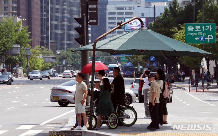 [서울=뉴시스] 조성봉 기자= 무더위가 계속되는 10일 오후 서울 종로구 광화문 사거리 횡단보도 그늘막에서 시민들이 신호를 기다리고 있다. 2023.07.10. suncho21@newsis.com