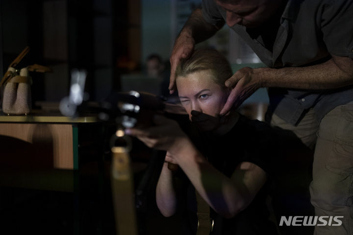 [키이우=AP/뉴시스] 11일(현지시각) 우크라이나 키이우에서 열린 민간인 대상 총기 훈련 참가자가 AK-47 모의 소총을 들고 겨누는 방법을 배우고 있다. 2023.07.12.