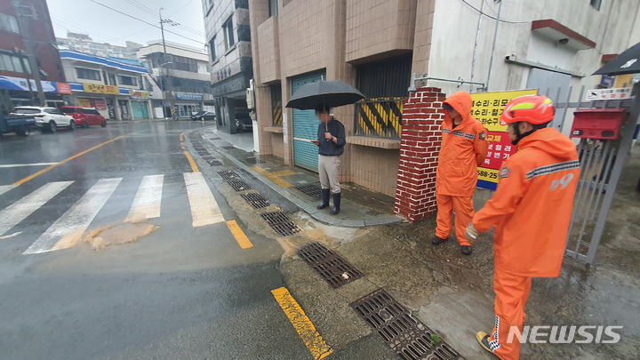 [통영=뉴시스] 홍정명 기자=12일 오전 7시 23분께 통영시 무전동 무전동주민센터 앞 맨홀 역류 신고가 접수돼 출동한 통영소방서 대원들이 안전조치를 취하고 있다.(사진=경남소방 제공) 2023.07.12. photo@newsis.com