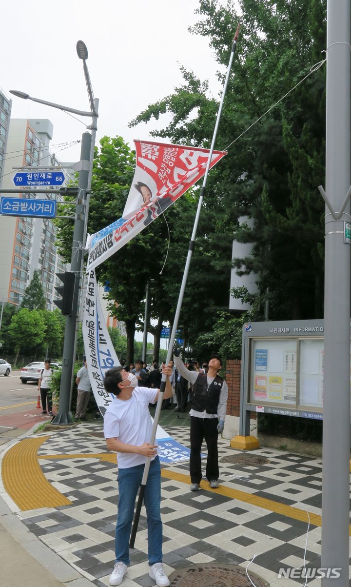 [인천=뉴시스] 김동영 기자 = 인천 연수구 관계자들이 12일 오전 인천 연수구 소금밭 사거리에서 정당현수막을 강제 철거하고 있다. 전국 지자체들이 정당현수막 난립 문제를 해결하기 위해 정치권에 협조를 요청하고 있는 가운데 직접 조례를 개정해 정당현수막을 강제로 제한하는 것은 인천시가 최초다. 2023.7.12. dy0121@newsis.com