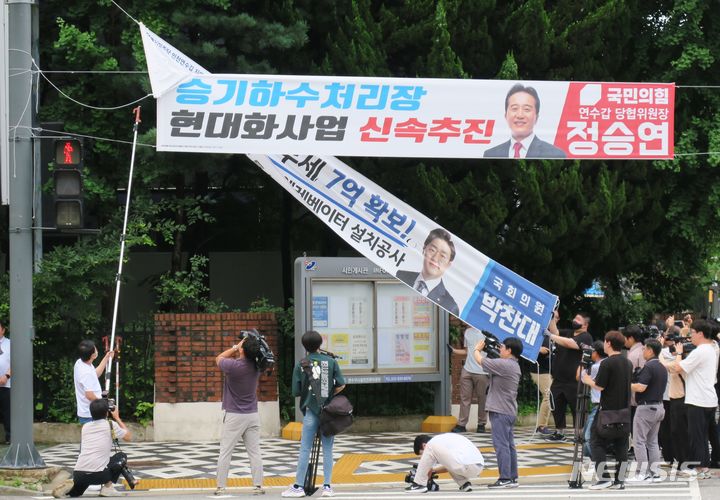 [인천=뉴시스] 김동영 기자 = 인천 연수구 관계자들이 12일 오전 인천 연수구 소금밭 사거리에서 정당현수막을 강제 철거하고 있다. 전국 지자체들이 정당현수막 난립 문제를 해결하기 위해 정치권에 협조를 요청하고 있는 가운데 직접 조례를 개정해 정당현수막을 강제로 제한하는 것은 인천시가 최초다. 2023.7.12. dy0121@newsis.com 