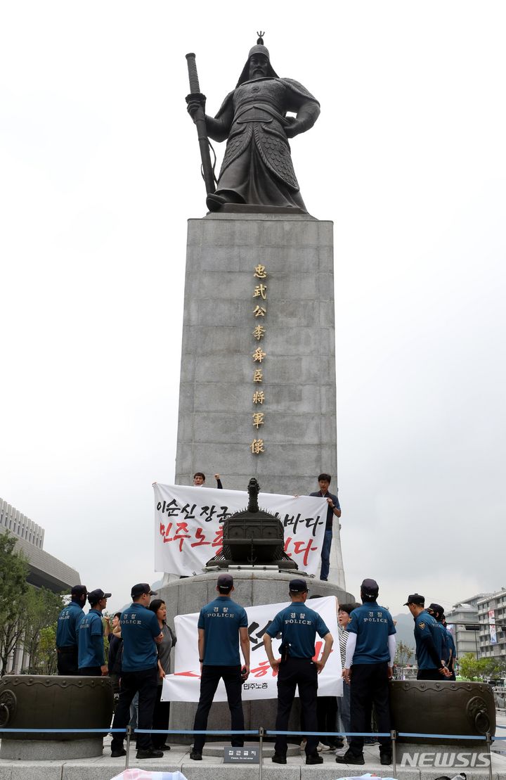 [서울=뉴시스] 조성봉 기자= 12일 오전 서울 종로구 광화문 이순신 동상 위에서 민주노총 조합원들이 ‘일본 후쿠시마 오염수 해양투기 반대’, ‘윤석열 대통령 퇴진’ 등 구호를 외치며 기습시위를 하고 있다. 2023.07.12. suncho21@newsis.com