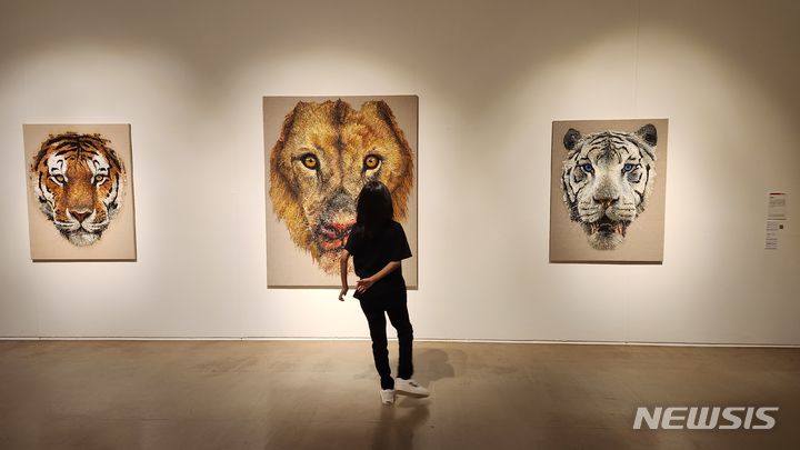 [서울=뉴시스]12일 개막한 뉴시스가 주목한 '아트픽 30' 전에 선보인 김남표 작가의 호랑이 그림을 한 초등학생 관람객이 감상하고 있다. 