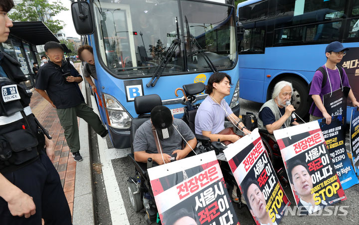 [서울=뉴시스] 김명년 기자 = 13일 오전 서울 종로구 혜화동로터리에서 한 시민이 출근길 버스를 가로막은 박경석 전국장애인차별철폐연대 대표와 회원들에게 항의하고 있다. 2023.07.13. kmn@newsis.com