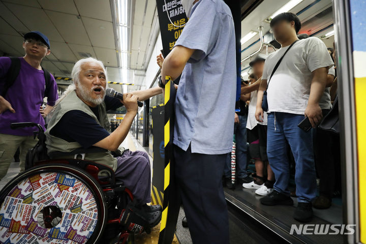 [서울=뉴시스] 김명년 기자 = 박경석 전국장애인차별철폐연대 대표가 13일 오전 혜화역 승강장에서 지하철 탑승을 저지당하고 있다. 2023.07.13. kmn@newsis.com