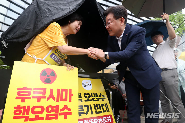 [서울=뉴시스] 국회사진기자단 = 이재명 더불어민주당 대표가 13일 오후 서울 종로구 일본대사관 앞에 마련된 단식농성장을 방문해 후쿠시마 오염수 방류 저지를 위해 18일째 단식 중인 이정미 정의당 대표를 만나 악수를 나누고 있다. 2023.07.13. photo@newsis.com
