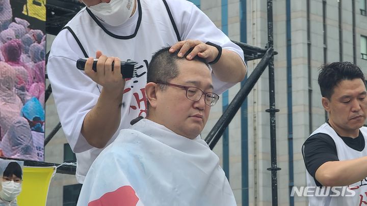 [부산=뉴시스] 권태완 기자 = 14일 오후 부산 동구 부산역 광장에서 보건의료노조 부산본부 부산대병원지부가 총파업 출정식을 진행하고 있다. 이날 출정식에서 노조 간부들이 결의를 다지는 삭발식을 하고 있다. 2023.07.14. kwon97@newsis.com