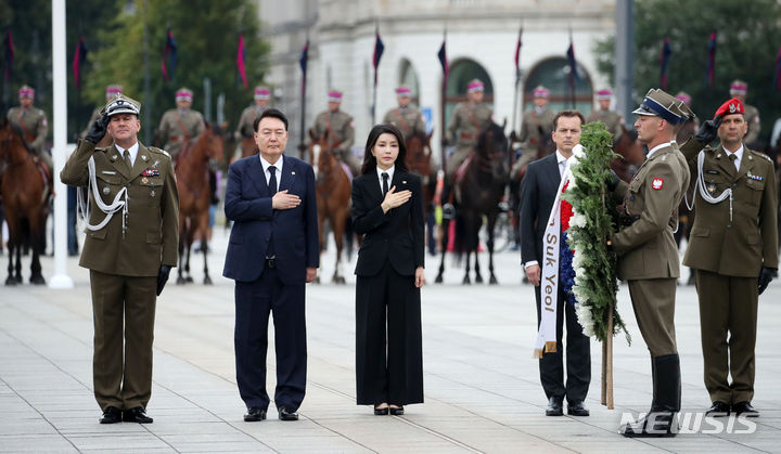 [바르샤바(폴란드)=뉴시스] 전신 기자 = 폴란드를 공식 방문 중인 윤석열 대통령과 부인 김건희 여사가 13일(현지시간) 바르샤바 무명용사의 묘를 찾아 애국가 연주에 국기에 대한 경례를 하고 있다. 2023.07.14. photo1006@newsis.com