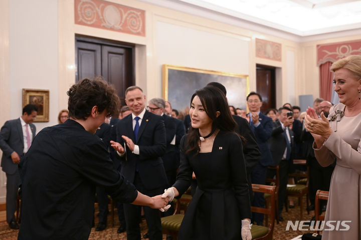 [바르샤바(폴란드)=뉴시스] 홍효식 기자 = 윤석열 대통령 부인 김건희 여사가 13일(현지시간) 바르샤바 대통령궁에서 열린 공식 만찬에서 피아노 연주자인 마테우시 두비엘을 격려하고 있다. (공동취재) 2023.07.14. yesphoto@newsis.com