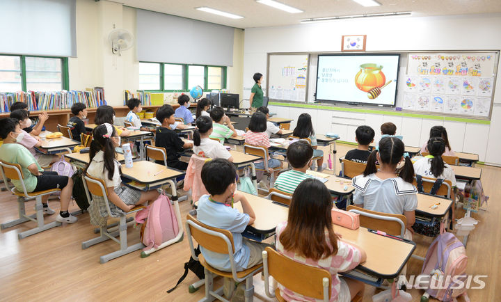 [서울=뉴시스] 초등학교 학생들이 교실에서 선생님으로부터 방학 중 주의사항을 듣고 있다. (사진=뉴시스 DB). photo@newsis.com