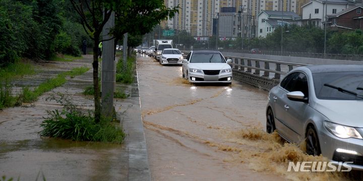 [광주=뉴시스] 변재훈 기자 = 폭우가 내린 14일 오전 광주 북구 신용동 신용지하차도 옆 1차선 도로(북광주IC 방면)에 인근 경사면에서 흘러내린 토사로 인한 흙탕물이 들어 차 있다. 2023.07.14. wisdom21@newsis.com