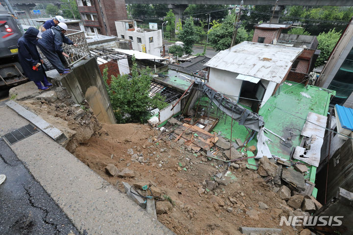 [서울=뉴시스] 황준선 기자 = 14일 오전 폭우로 축대가 무너진 서울 서대문구 홍제천로의 한 도로에서 서대문구 관계자들이 복구작업을 하고 있다. 2023.07.14. hwang@newsis.com