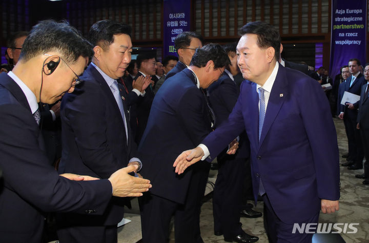 [바르샤바(폴란드)=뉴시스] 홍효식 기자 = 윤석열 대통령이 14일(현지시간) 바르샤바 한 호텔에서 열린 한-폴란드 비즈니스 포럼에 입장하며 정연인 두산에너빌리티 사장과 악수하고 있다. 2023.07.14. yesphoto@newsis.com