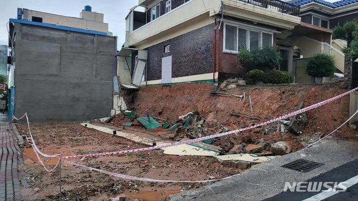 [광주=뉴시스] 김혜인 기자 = 15일 오후 광주 남구 월산동 한 빈집의 담장이 폭우로 무너져 관할 지자체인 남구가 안전 조치를 하고 있다. 2023.07.15. (사진=광주남구 제공) photo@newsis.com