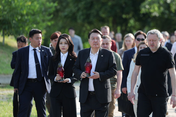 [키이우(우크라이나)=뉴시스] 전신 기자 = 윤석열 대통령과 부인 김건희 여사가 15일(현지시간) 키이우 인근 부차 희생자들의 무덤에 조성된 추모공간을 방문하고 있다. (사진=대통령실 제공) 2023.07.15. photo@newsis.com *재판매 및 DB 금지