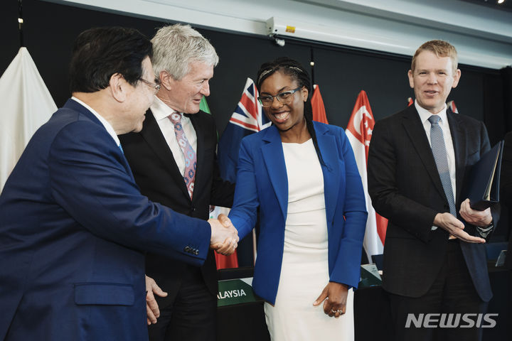 [오클랜드(뉴질랜드)=AP/뉴시스] 16일(현지시간) 뉴질랜드 오클랜드에서 열린 포괄적·점진적 환태평양경제동반자협정(CPTPP) 각료회의에서 영국은 일본과 다른 10개국을 포함하는 아시아태평양 무역 그룹에 공식적으로 합류했다. 데미안 오코너 뉴질랜드 통상장관, 크리스 힙킨스 뉴질랜드 총리(오른쪽)가 지켜보는 가운데 케미 바데노크 영국 국제통상부 장관(오른쪽 두번째)이 고토 시게유키 일본 경제재생담당상(왼쪽)과 악수하고 있다.2023.07.17.