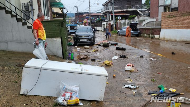 [공주=뉴시스] 송승화 기자 = 기록적인 폭우로 인근에서 사망자 1명이 발생한 충남 공주시 옥룡동 버드나무길에 이른 아침부터 복구를 위해 집을 찾은 60대 주민이 망연자실 토사로 엉망이 된 도로를 보고 있다. 2023.07.16. ssong1007@newsis.com