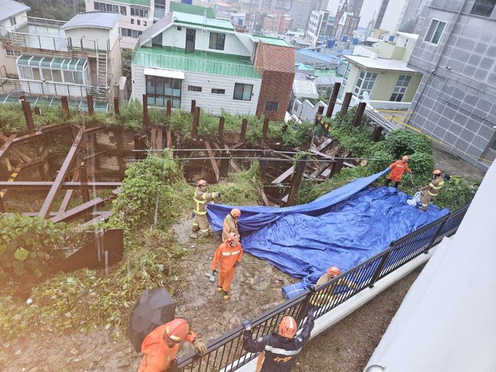 [부산=뉴시스] 이동민 기자 = 호우경보가 발효 중인 16일 오후 부산 부산진구의 한 공사장에서 토사가 흘러내려가는 사고가 발생해 소방이 안전조치를 취하고 있다. (사진=부산소방재난본부 제공) 2023.07.16. photo@newsis.com *재판매 및 DB 금지