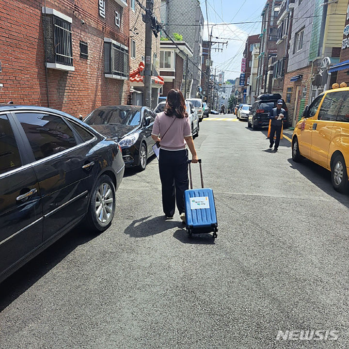 [성남=뉴시스] 성남시 해오름도서관 직원이 독서소외계층 아동에 빌려줄 책을 캐리어에 담아 배달 중이다