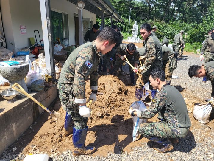 [군산=뉴시스] 고석중 기자= 17일 천마부대 독기잇빨대대 장병 40여명이 전북 군산시 옥산면 일대의 토사 유출 현장에서 수해복구 작업에 구슬땀을 흘리고 있다.(사진=군산시 제공) 2023.07.17. photo@newsis.com *재판매 및 DB 금지