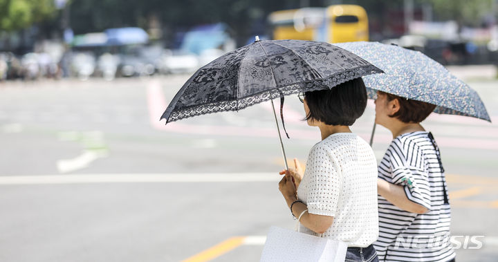 [서울=뉴시스] 정병혁 기자 = 절기상 중복(中伏)이자 금요일인 21일은 전국 대부분 지역에 폭염특보가 발효된 가운데, 찜통더위가 이어지겠다. 내륙을 중심으로는 돌풍과 천둥·번개를 동반한 소나기가 내리겠다. 사진은 지난 20일 서울 중구 세종대로에서 시민들이 양산으로 햇빛을 가린 채 이동하고 있는 모습. 2023.07.20. jhope@newsis.com