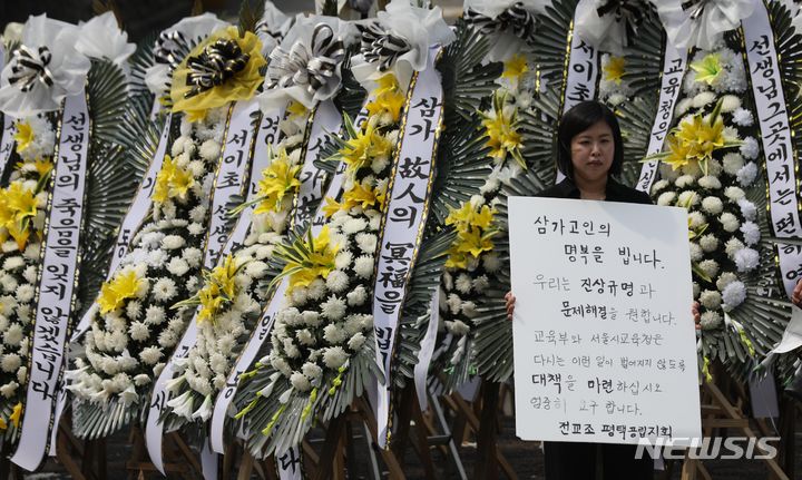 [서울=뉴시스] 조수정 기자 =지난 20일 오후 서울 종로구 서울시교육청 앞에서 전교조 평택공립지회 소속 교사가 서울 초등학교 교사 사망과 관련, 고인의 명복을 빌며 진상규명과 문제 해결 등을 촉구하는 팻말을 들고 있다. 2023.07.20. chocrystal@newsis.com