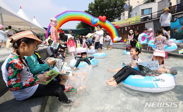 [서울=뉴시스] 최진석 기자 = 절기상 중복인 21일 서울 송파구 성내천 물놀이장을 찾은 어린이들이 책을 읽으며 물놀이를 즐기고 있다. 송파구는 이날부터 23일까지 성내천 물놀이장에서 '하하호호 함께 즐기는 BOOK 놀이터'를 오전 10시부터 오후 5시까지 운영한다. 2023.07.21. myjs@newsis.com