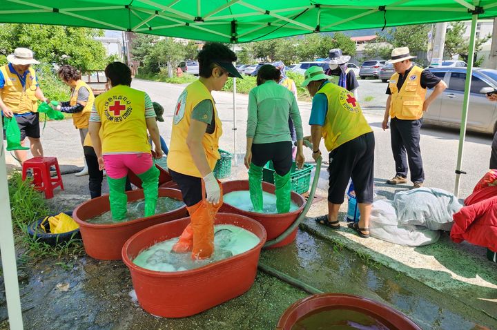 [괴산=뉴시스] 강신욱 기자 = 대한적십자봉사회 괴산지구협의회 회원들이 집중호우로 침수 피해를 본 불정면 하문리에서 세탁 봉사활동을 하고 있다. (사진=괴산군 제공) 2023.07.23. photo@newsis.com *재판매 및 DB 금지