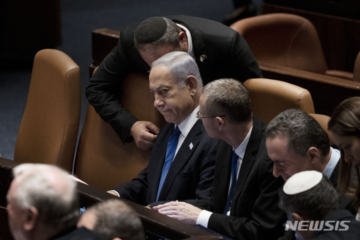 [AP/뉴시스] 이스라엘의 네타냐후 총리가 심장맥박 자동조절기 삽입수술을 마친 지 반나절 후인 24일 낮 반년 간 추진해온 대법원권한축소 법안 최종투표를 하기 위해 의회에 나와 의원들과 논의하고 있다. 유대교 캡을 쓴 의원이 초강경국수주의자 이타마르 벤그비르 국가안보 장관이며 오른쪽 옆에 야리브 레빈 법무장관이다. 2023. 07. 24.&nbsp; 