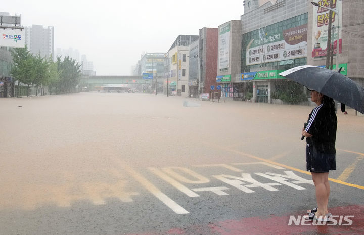[목포=뉴시스] 이창우 기자=24일 오전 집중호우로 침수된 목포시 석현동 일대 도로 현장을 주변 상인들이 망연자실 지켜보고 있다. (사진=전남도 제공) 2023.07.24. photo@newsis.com *재판매 및 DB 금지