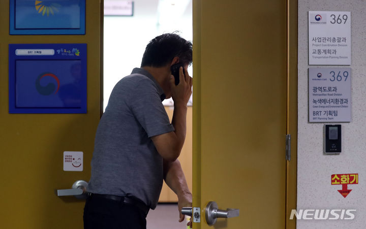 [세종=뉴시스] 강종민 기자 = 검찰이 충북 청주 오송 궁평2지하차도 침수사고 관련 5개 기관 동시 압수수색에 들어간 24일 오전 세종시 정부세종청사 행정중심복합도시건설청 광역도로과 사무실로 관계자가 전화통화를 하며 들어가고 있다. 2023.07.24. ppkjm@newsis.com