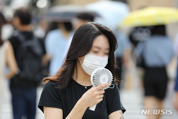 [서울=뉴시스] 황준선 기자 = ﻿﻿폭염으로 유독 더위를 타고 땀이 많이 나는 사람들이 있다. 갑상선에서 갑상선 호르몬이 과다 분비되는 갑상선 기능 항진증 환자들이다. 평소보다 더 더위를 참기 힘들고 땀을 흘리고 식욕이 왕성해 잘 먹는데도 오히려 체중이 준다면 갑상선 기능 항진증을 의심해 봐야 한다.장마기간이 끝나고 이른아침부터 무더운 날씨를 보인 27일 오전 서울 종로구 세종대로 사거리에서 한 시민이 휴대용 선풍기를 사용하며 발걸음을 옮기고 있다. 2023.07.27. hwang@newsis.com