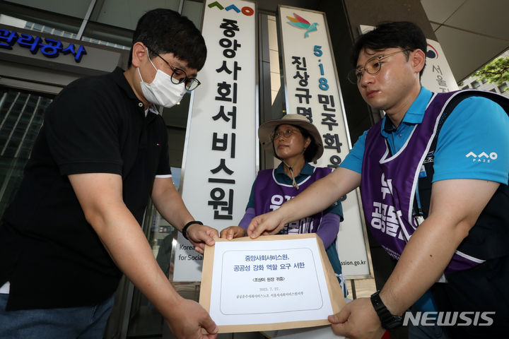 [서울=뉴시스] 민주노총 공공운수노조 서울시사회서비스원지부 조합원들이 2023년 7월 27일 오전 서울 중구 중앙사회서비스원 앞에서 '중앙사회서비스원의 공공성 강화 역할 요구 서한'을 관계자에게 전달하고 있는 모습. (사진=뉴시스 DB) 2023.07.27. photo@newsis.com