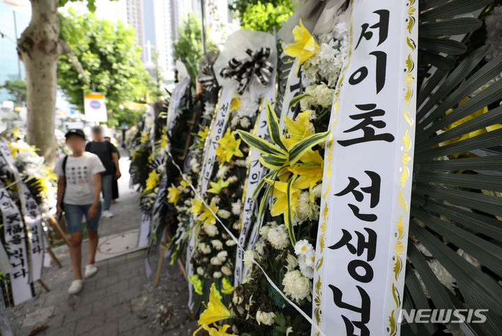 [서울=뉴시스] 김선웅 기자 =지난달 27일 서울 서초구 서이초등학교에 학부모의 괴롭힘으로 추정되는 이유로 최근 스스로 목숨을 끊은 서이초 신규 교사 추모 화환이 놓여 있다. 2023.07.27. mangusta@newsis.com