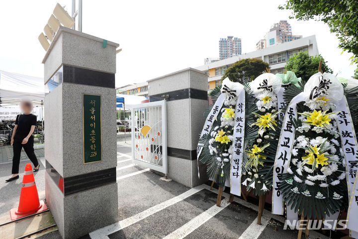 [서울=뉴시스] 김선웅 기자 = 이른바 '서이초 사건' 이후 교권 보호를 위한 제도적 정비가 이루어졌으나 교육 현장에선 후속 입법 조치가 필요하다는 요구가 여전하다. 지난해 7월27일 서울 서초구 서이초등학교 앞에 추모 화환이 놓여 있는 모습.  2023.07.27. mangusta@newsis.com